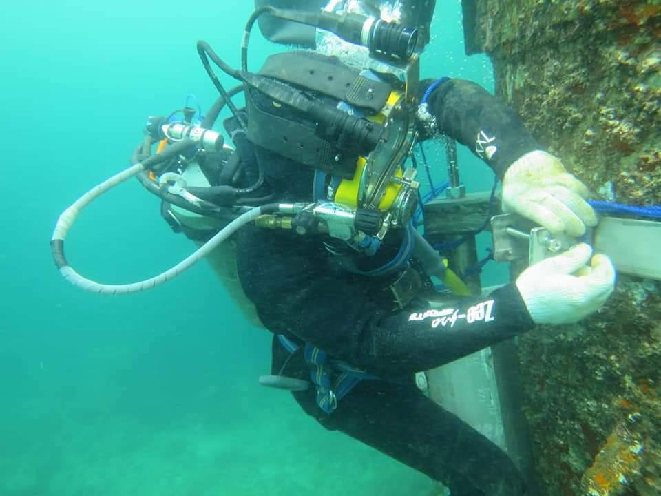 professional diver cleaning tank underwater